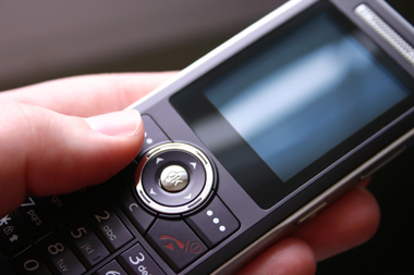 Picture of a hand operating a mobile phone (Edinburgh Maths Tuition)